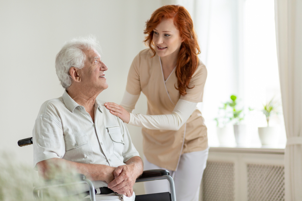 Caretaker talking with resident in wheelchair