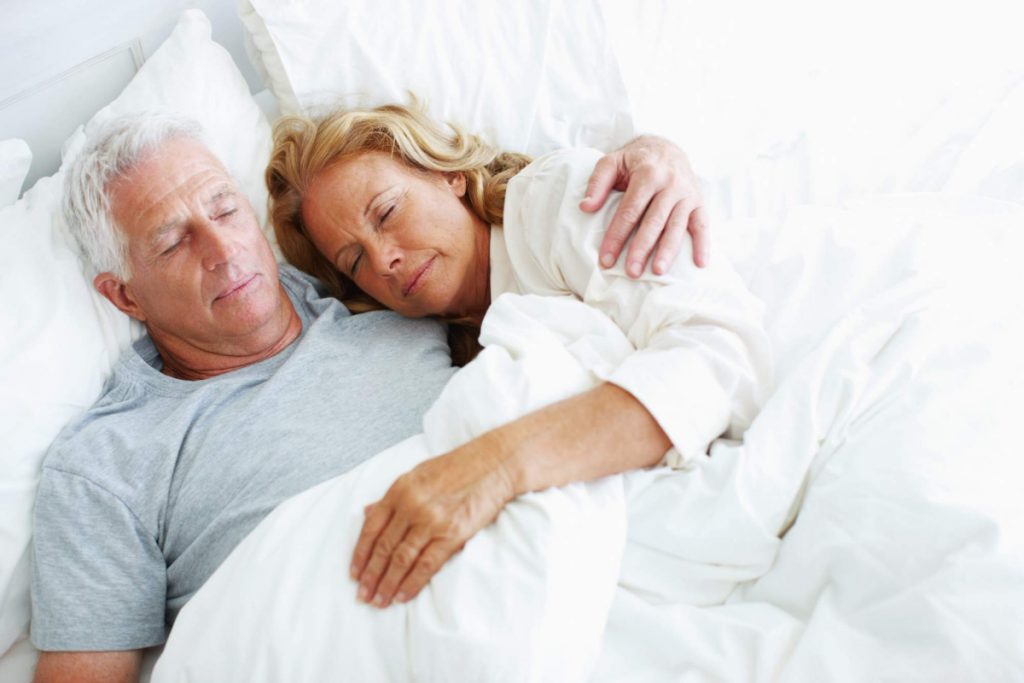 Elder couple asleep in bed