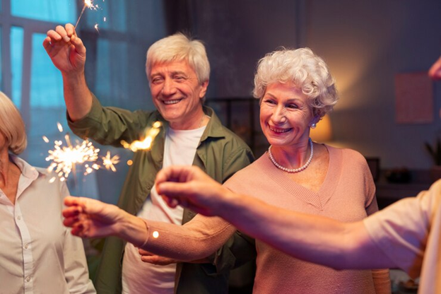 Seniors celebrating with sparklers, smiling and enjoying a festive Fourth of July evening together.