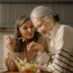 Elderly woman and younger caregiver sharing a warm moment in the kitchen during the holidays